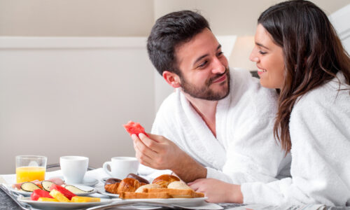 Couple eating breakfast in bed